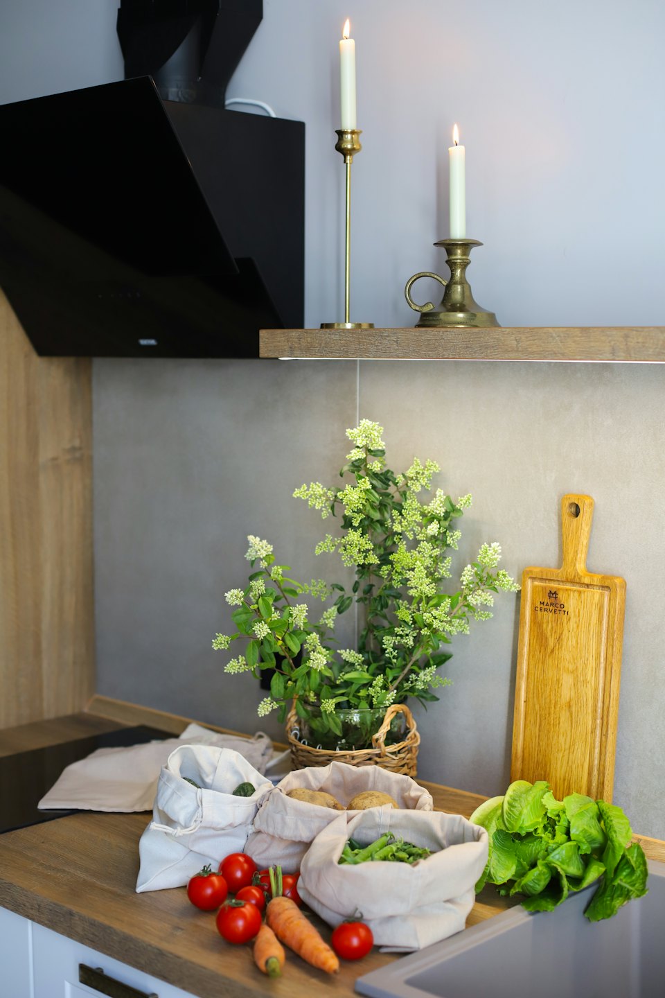 Fresh vegetables are arranged on a clean wooden kitchen counter.