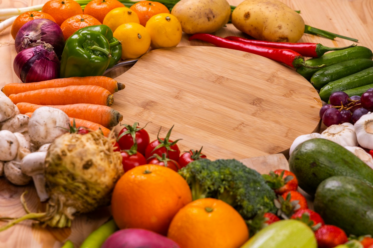 Fresh fruits and vegetables arranged on a wooden cutting board.