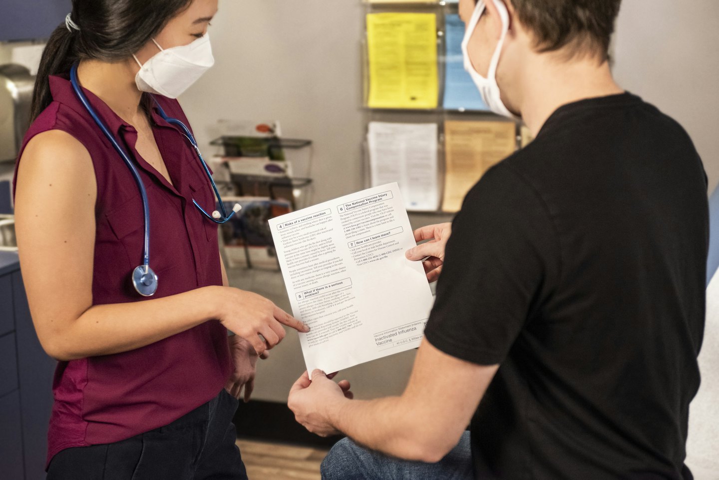 Medical professional points to document with patient in office.